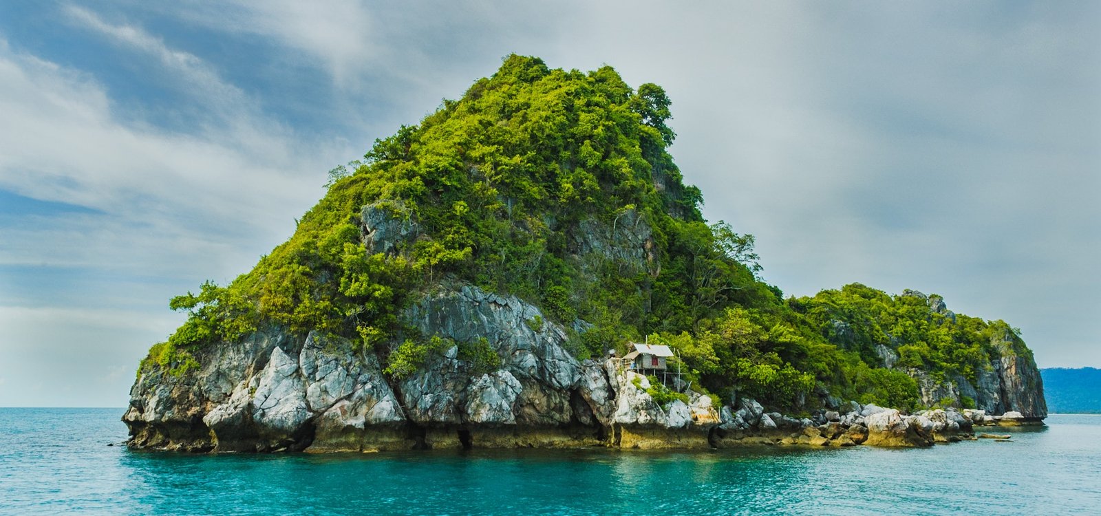 Lush tropical coastline rising from clear turquoise sea